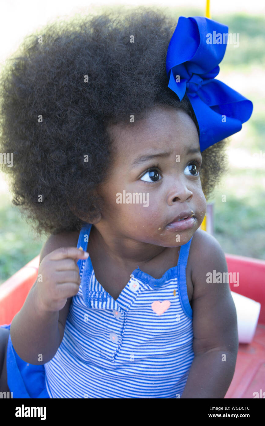 Close-up Of Cute Baby Girl With Blue Bow Tied On Curly Hair Stock ...