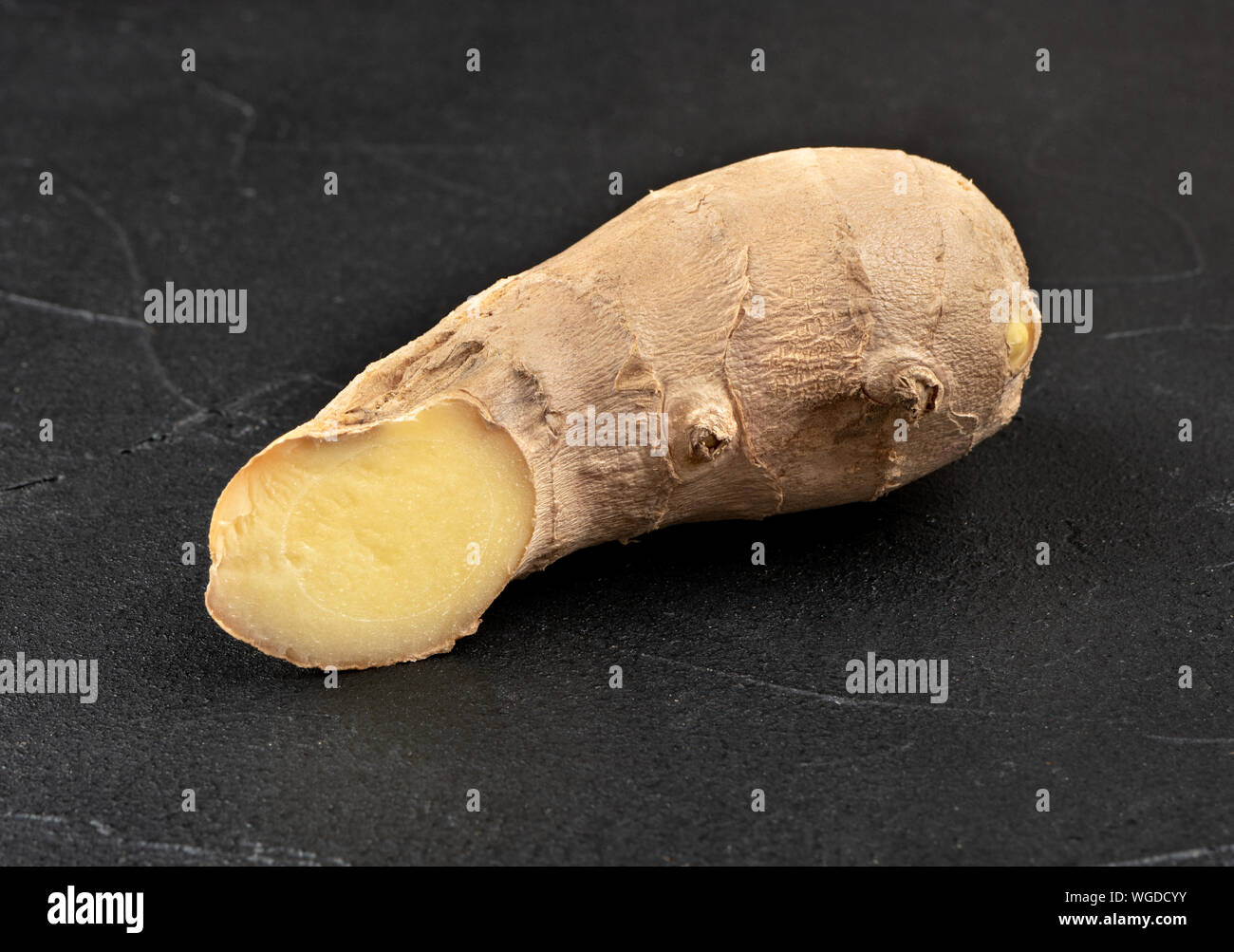 Fresh ginger root piece on dark concrete background Stock Photo