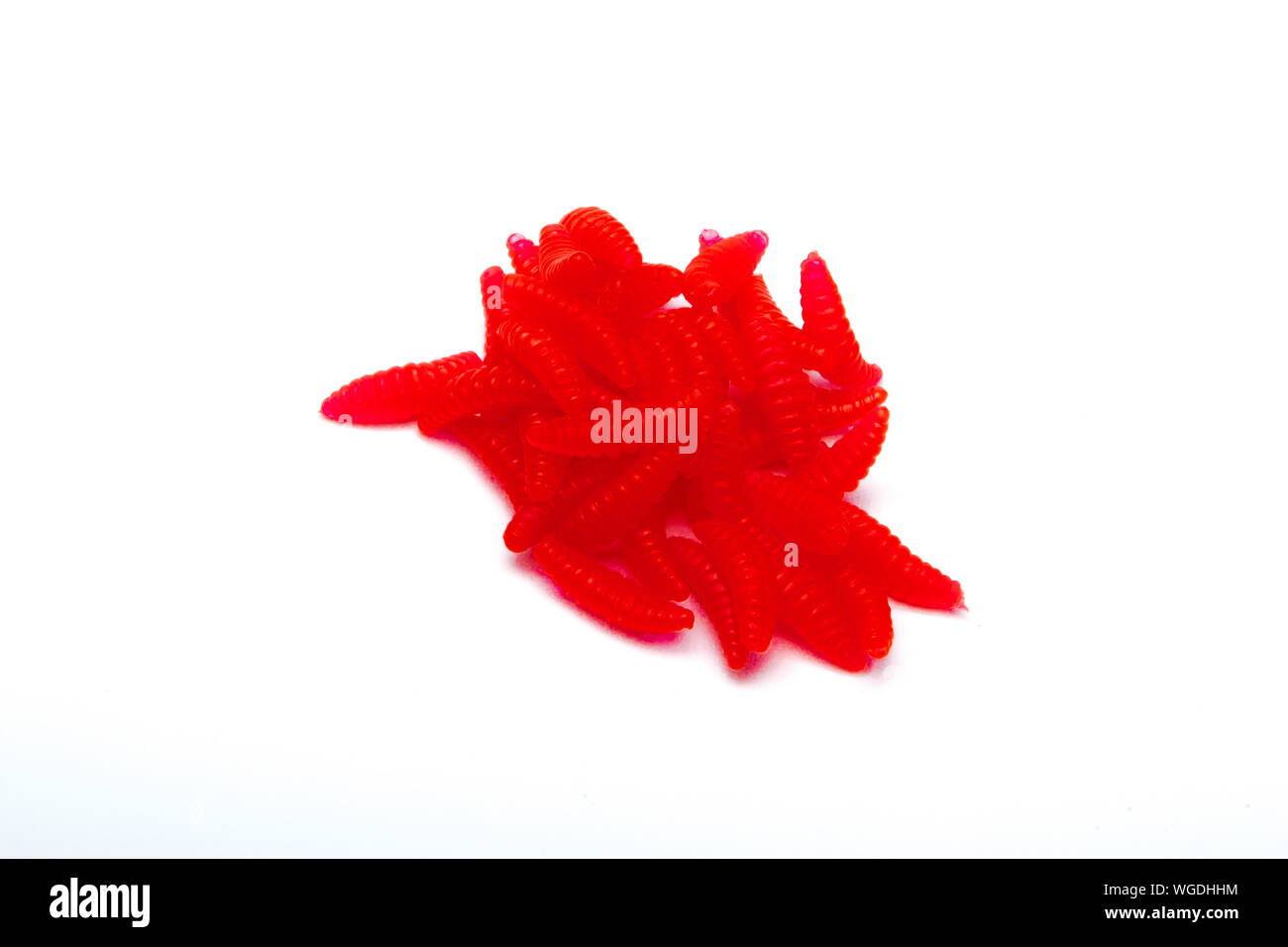 Red Artificial fishing larvae of insects on white background with soft shadow Stock Photo