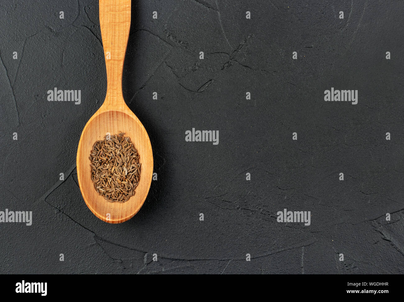 Large spoon with dry cumin close-up on concrete background Stock Photo