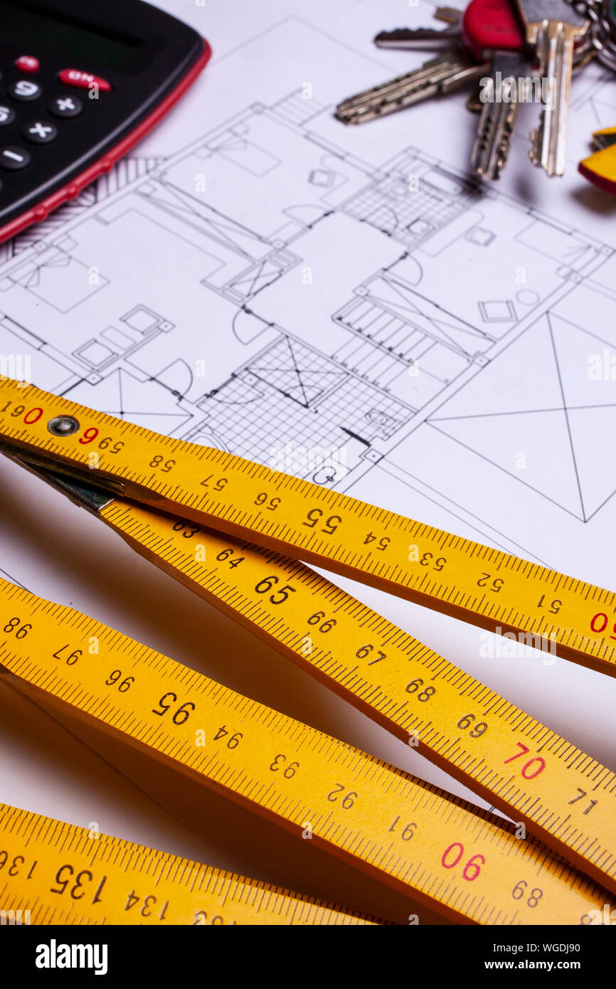 house blueprint, wood measuring stick and keys real estate concept