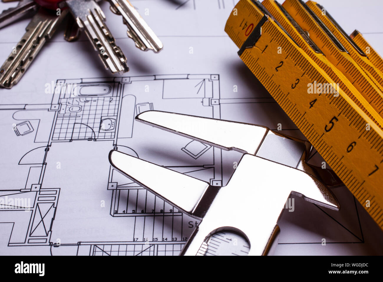 house blueprint, wood measuring stick, gauge and keys - real estate concept Stock Photo