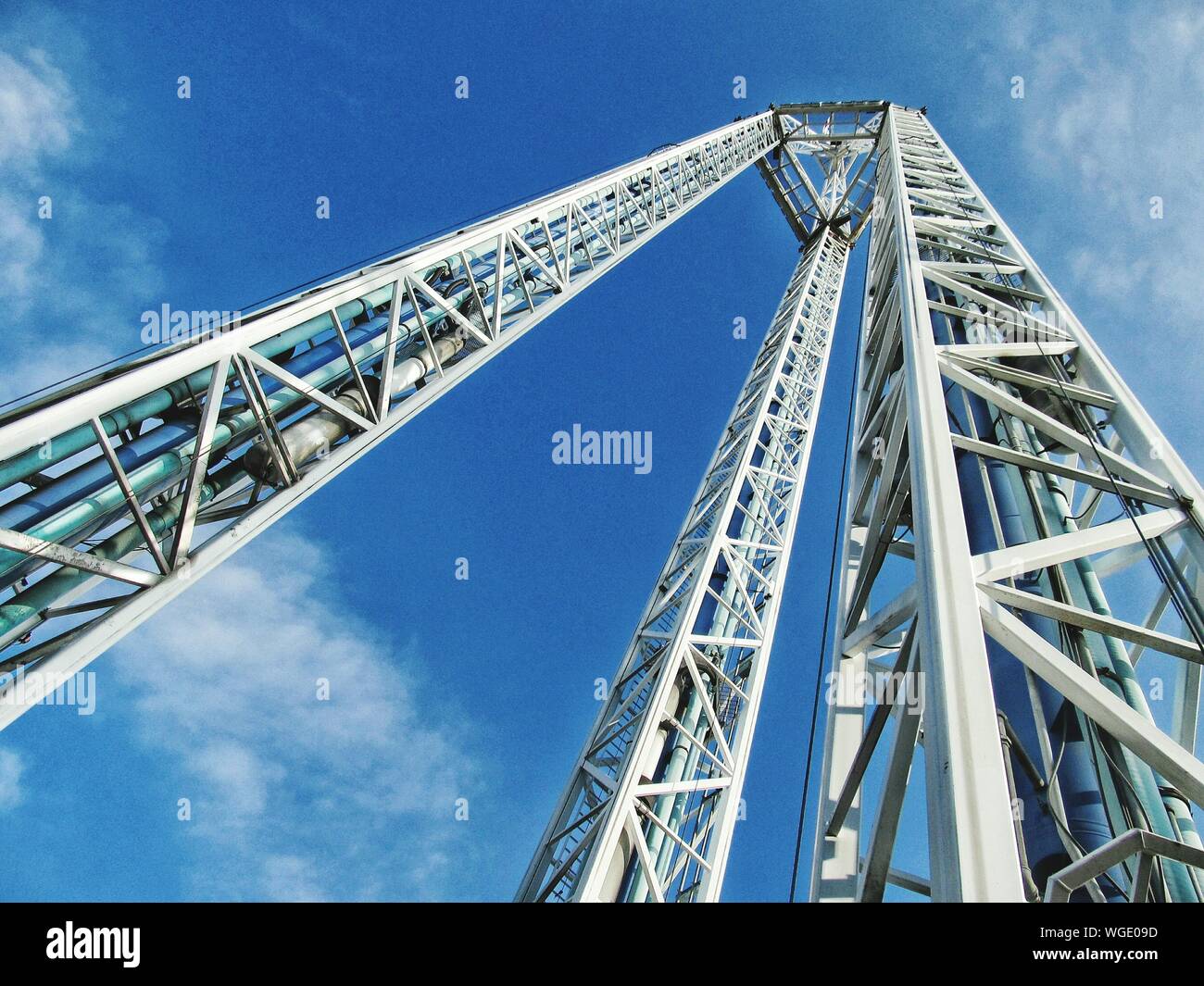 Low Angle View Of Free Falling Ride Against Blue Sky On Sunny Day Stock Photo