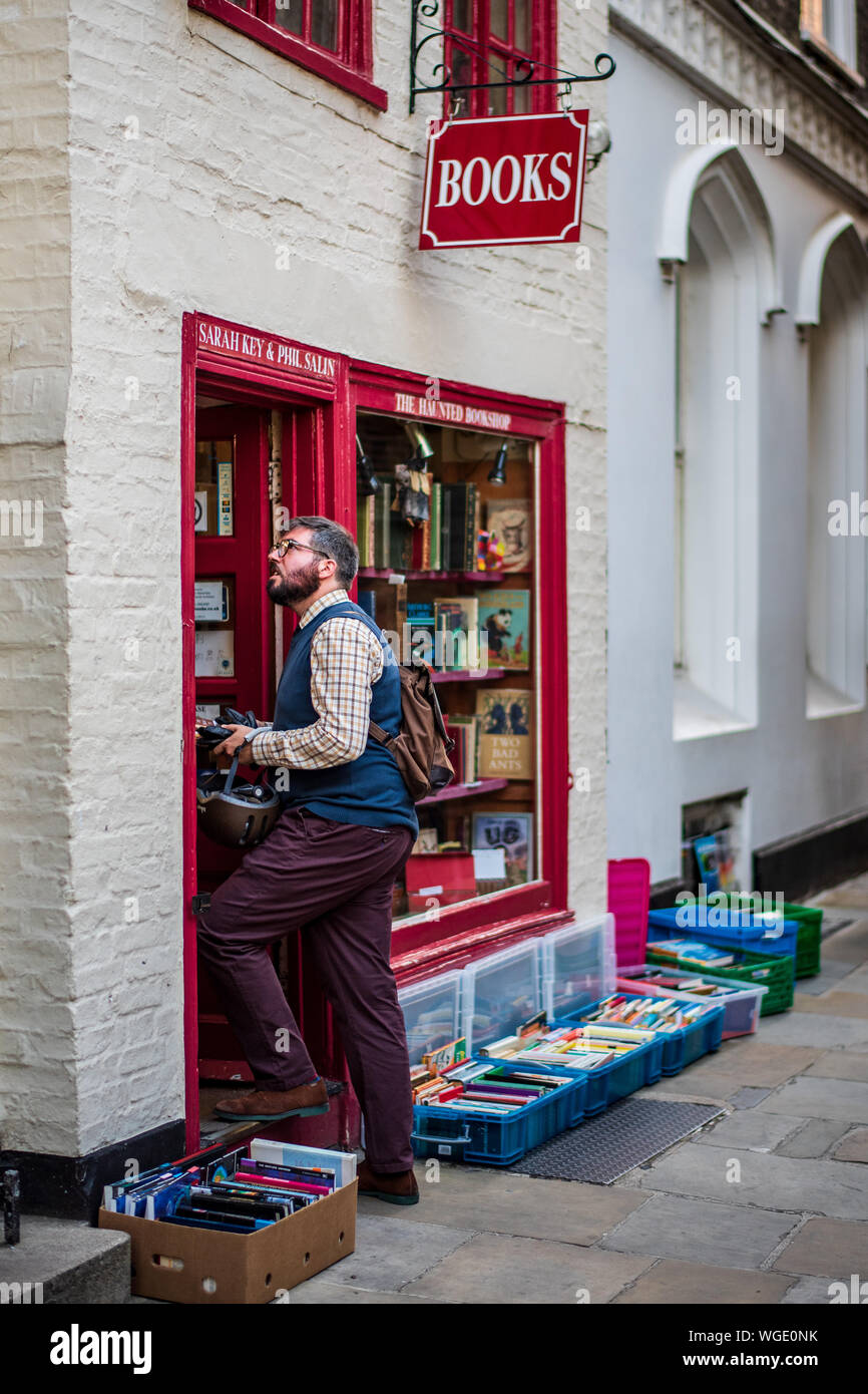 Haunted Bookshop Cambridge - a customer browses books in the famous Haunted Bookshop Book Store in St Edwards Passage in central Cambridge. Stock Photo