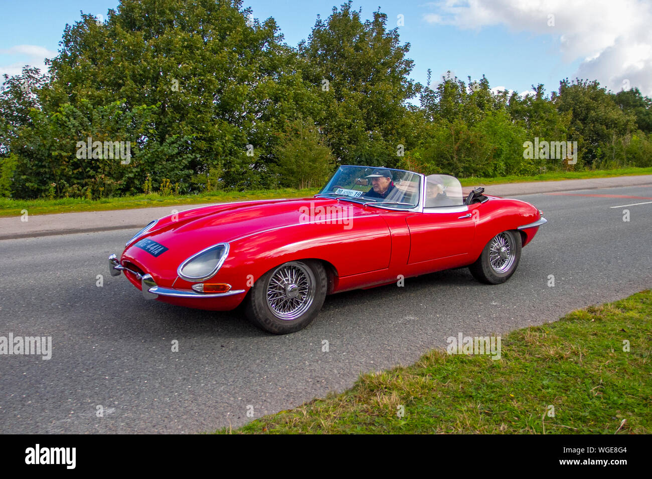 1963 60s red Jaguar 'E' Type driving in the 2019 Bradford to Morecambe Charity vintage car rally, old, retro vehicle, historic automobile, transportation, classic antique, collection, auto transport, design, motor, drive, historical, history, show, engine, restored collectible, style, historic vehicle run. Stock Photo
