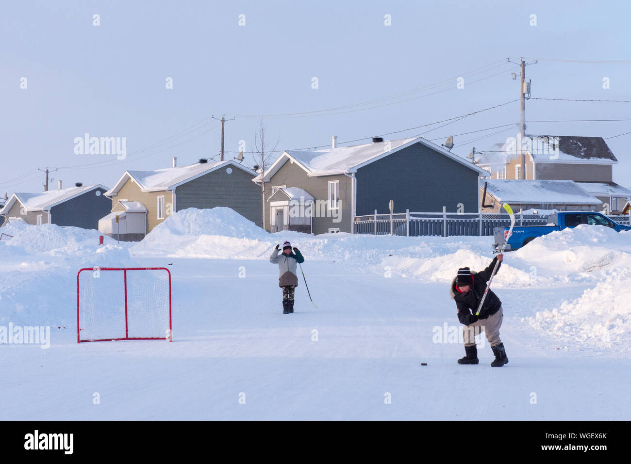 Indigenous children playing street hockey, Northern Quebec, Canada Stock Photo