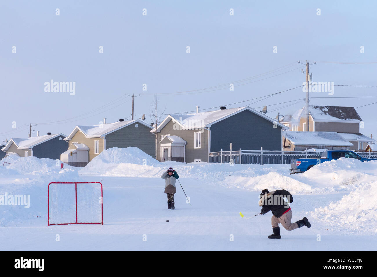 Indigenous children playing street hockey, Northern Quebec, Canada Stock Photo