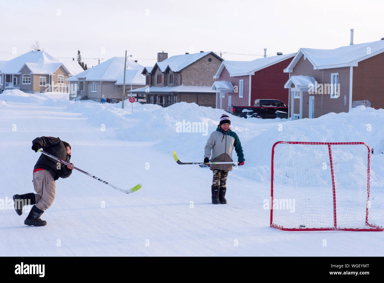 Indigenous boys playing street hockey in winter, Northern Quebec, Canada Stock Photo