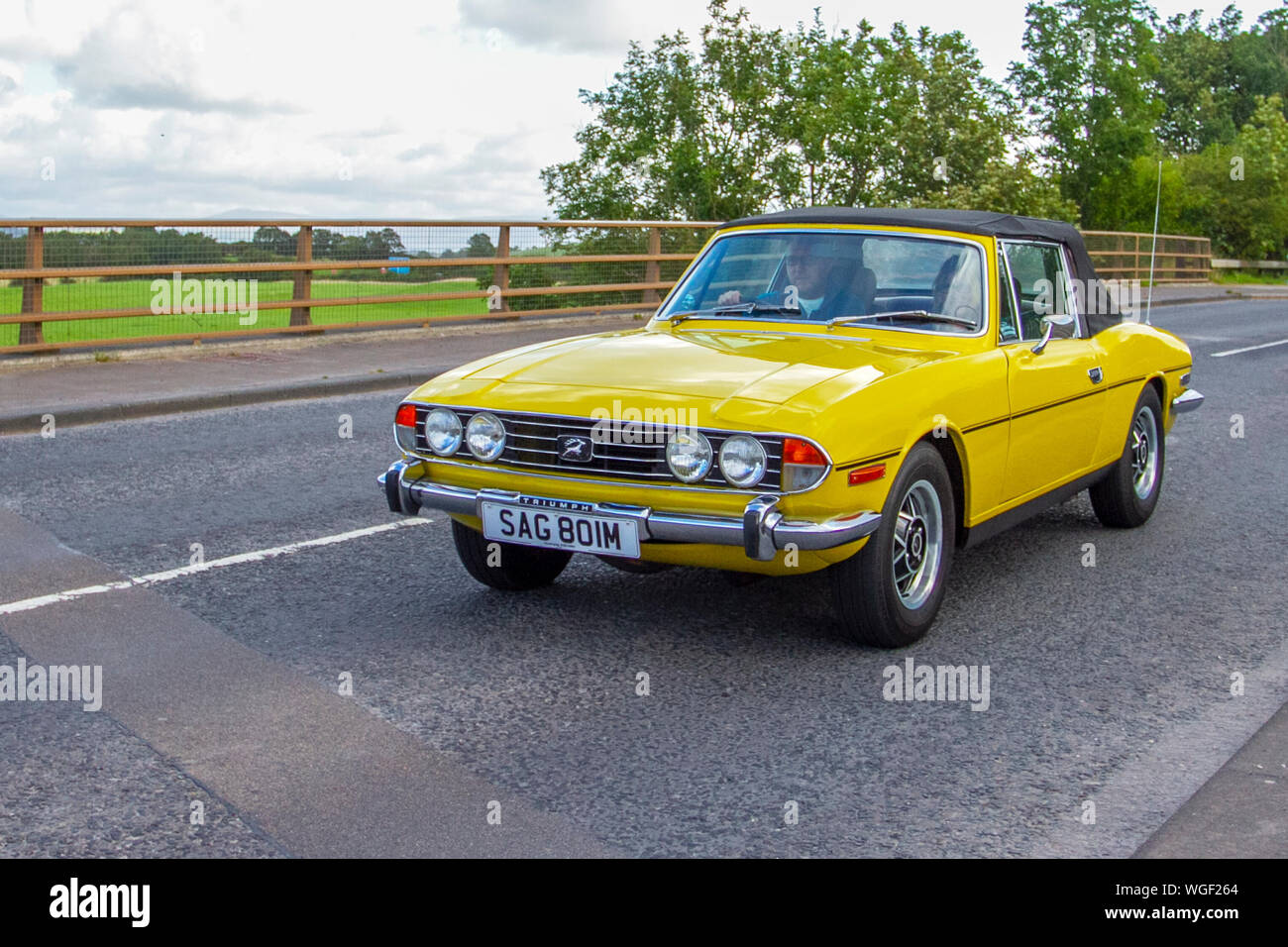 1973 70s yellow Triumph Stag 2997cc British sports card riving en-route Bradford to Morecambe Charity vintage historic vehicle run. Stock Photo
