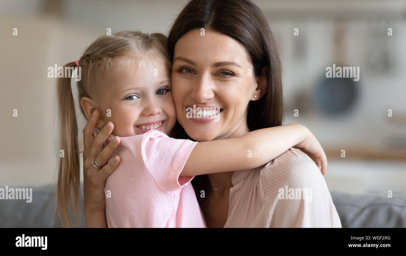 Mother and daughter embracing looking at camera feels happy Stock Photo