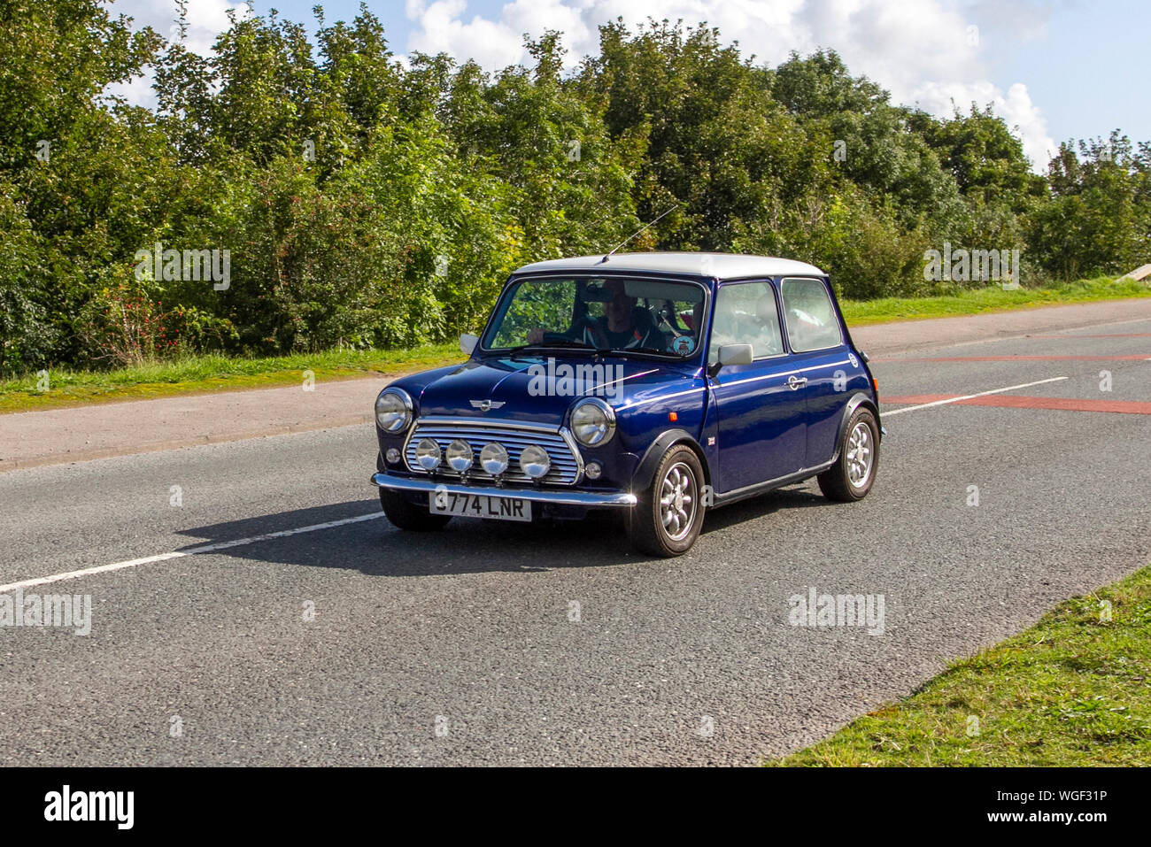 1998 90s blue white Rover Mini Cooper driving in the  Bradford to Morecambe Charity vintage car rally, old, retro vehicle, historic automobile, transportation, classic antique, collection, auto transport, design, motor, drive, historical, history, show, engine, restored collectible, style, historic vehicle run. Stock Photo