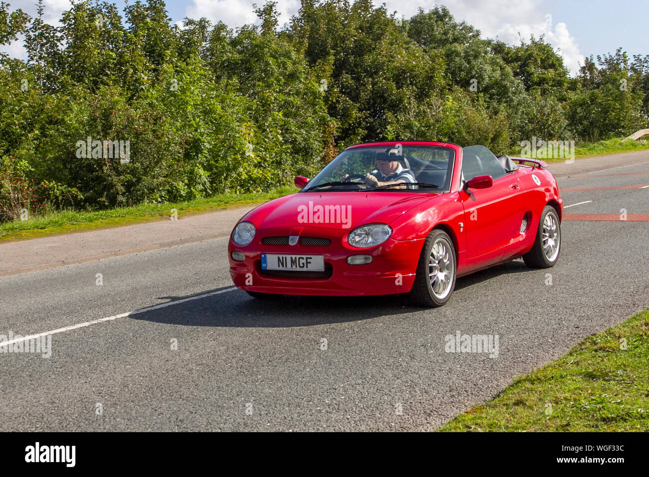 2001 red MG MGF VVC Freestyle driving in the 2019 Bradford to Morecambe Charity vintage car rally, old, retro vehicle, historic automobile, transportation, classic antique, collection, auto transport, design, motor, drive, historical, history, show, engine, restored collectible, style, historic vehicle run. Stock Photo