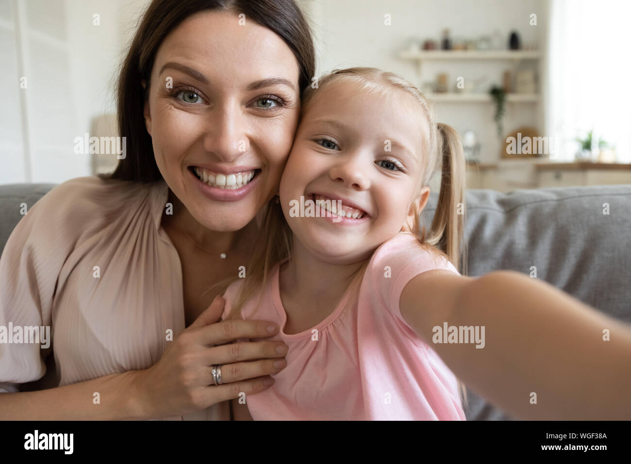 Webcam view daughter and mother sitting on couch at home Stock Photo - Alamy