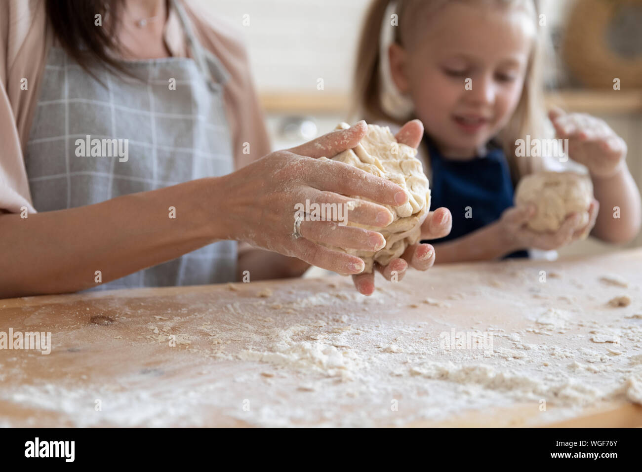Woman and daughter knead dough with hands close up view Stock Photo - Alamy
