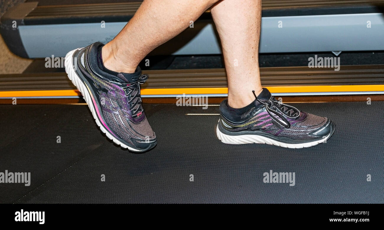 Runners lower legs and feet running on a treadmill indoors Stock Photo