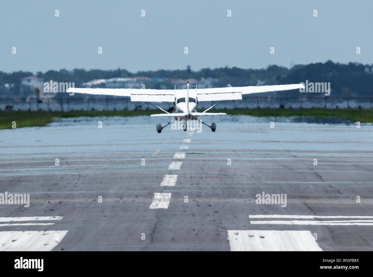 Small white Cessna plane taking off in the visible heat of Southern Florida. Stock Photo