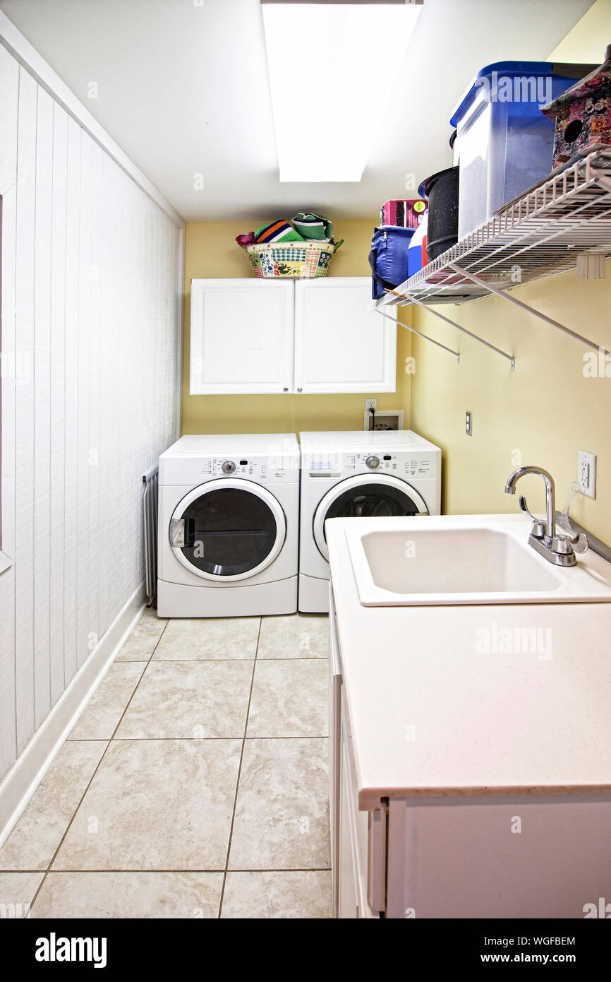 Laundry room interior. Utility room with washing machine, cleaning  equipment, home cleaners, clean wipes, hanging colorful shirts on  clothesline on wh Stock Photo - Alamy