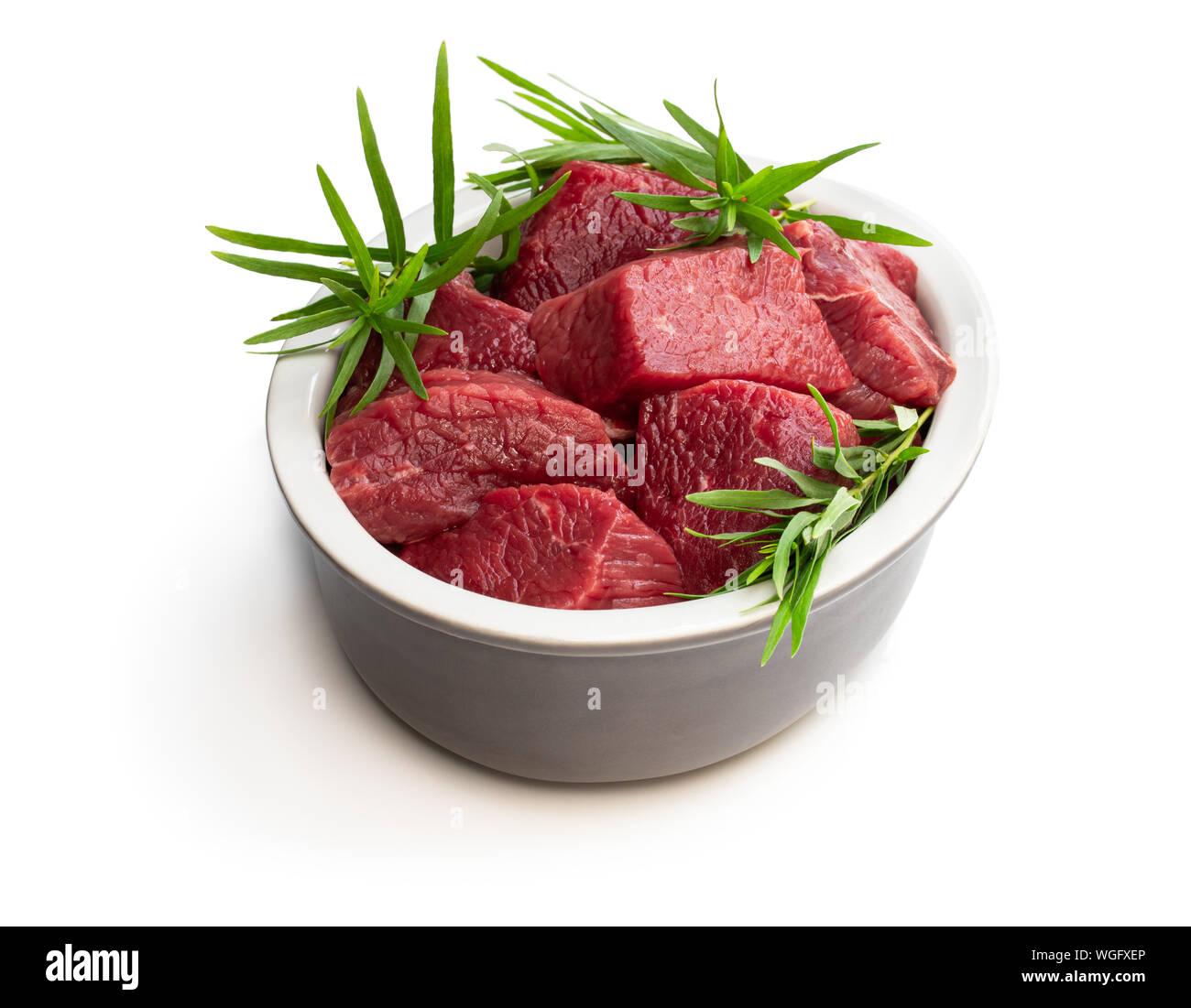 Sliced raw beef with tarragon herb isolated on white Stock Photo Alamy