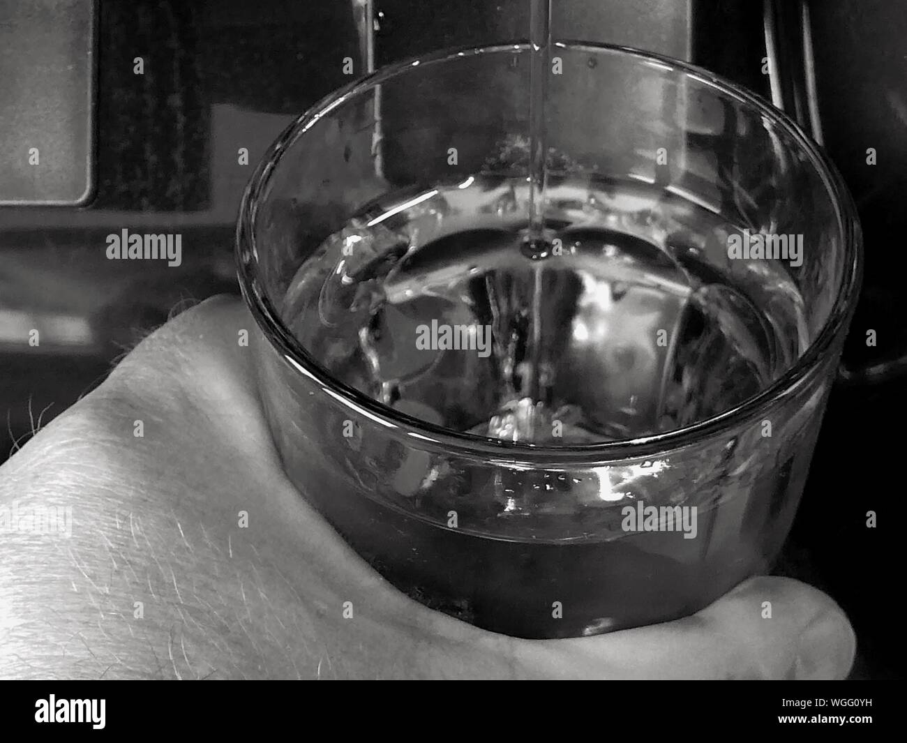 Cropped Image Of Hand Filling Water Into Glass Stock Photo