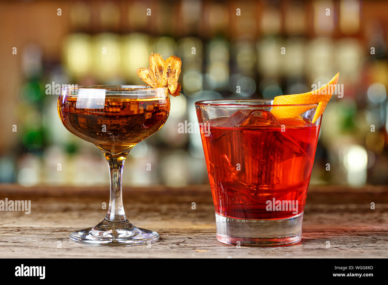 Whiskeybased cocktails stand on a shabby wooden bar counter in the