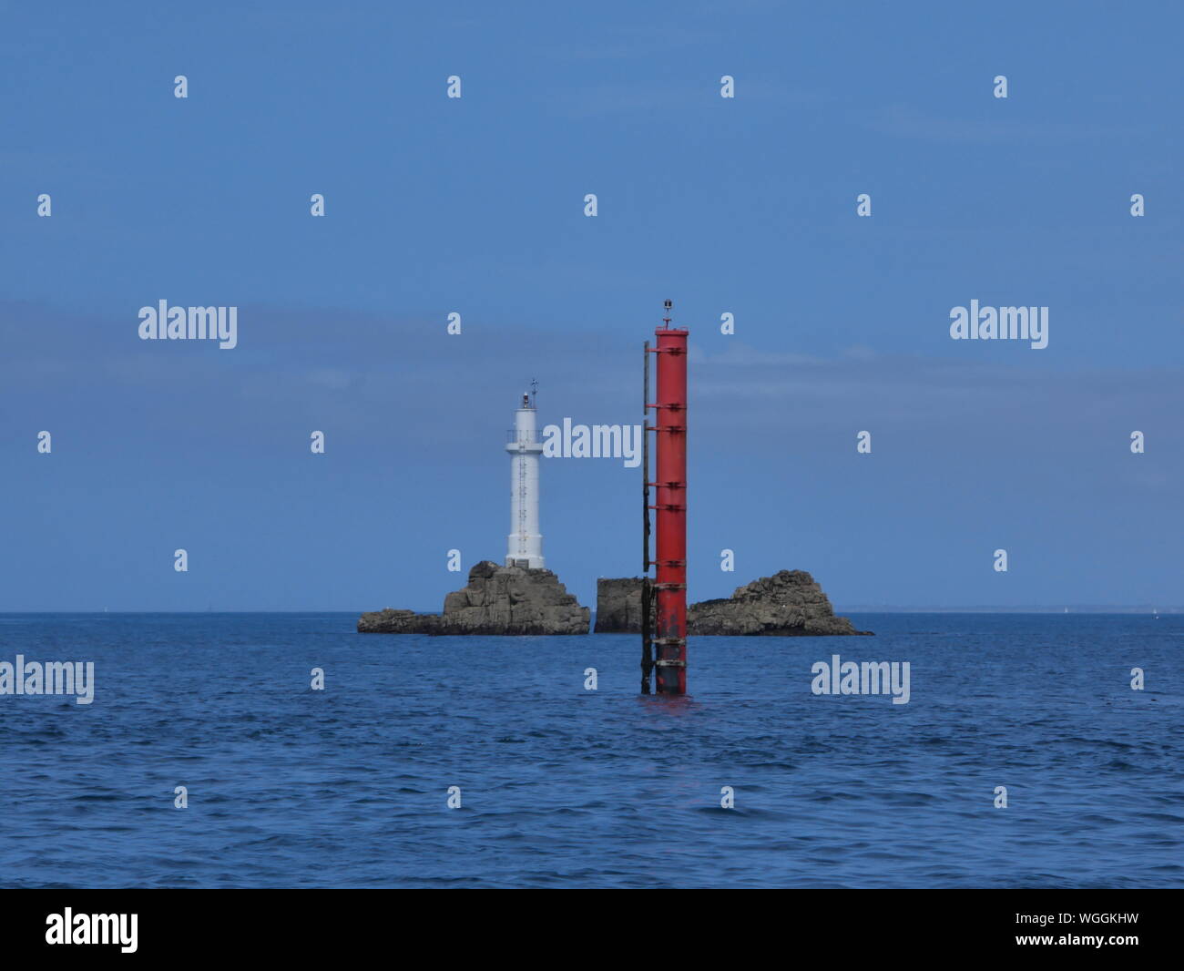 phare des trois pierres , phare blanc de l'île de molène , phare sur rocher en pleine mer , balise rouge , archipel de molène , île de ouessant       . Stock Photo