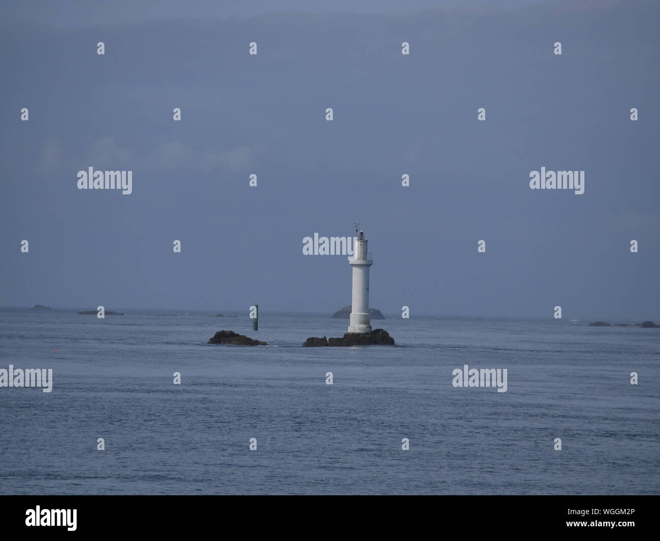 phare des trois pierres , phare blanc de l'île de molène , phare sur rocher en pleine mer , balise rouge , archipel de molène , île de ouessant       . Stock Photo