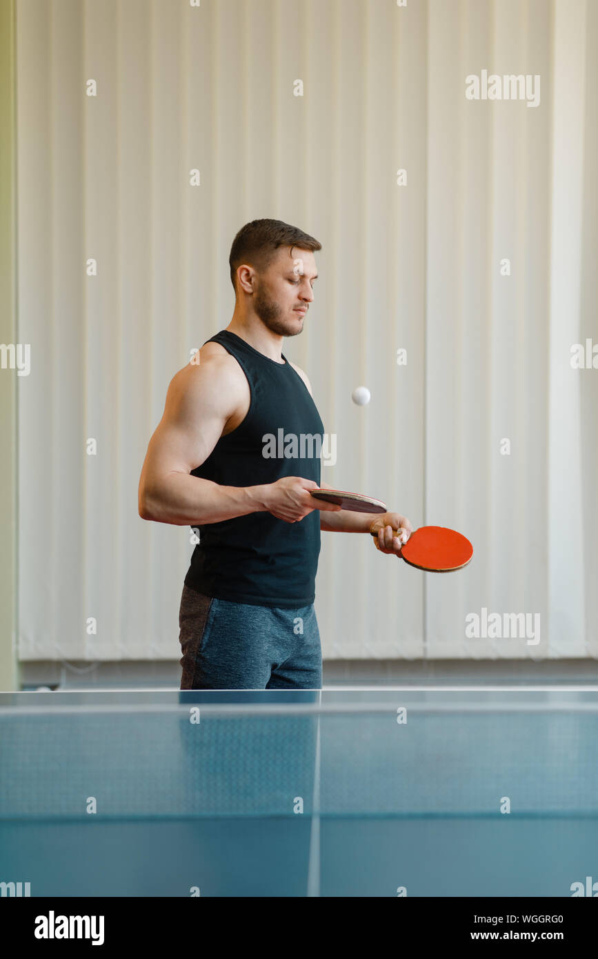 Man with two rackets stuffs blows in ping pong Stock Photo