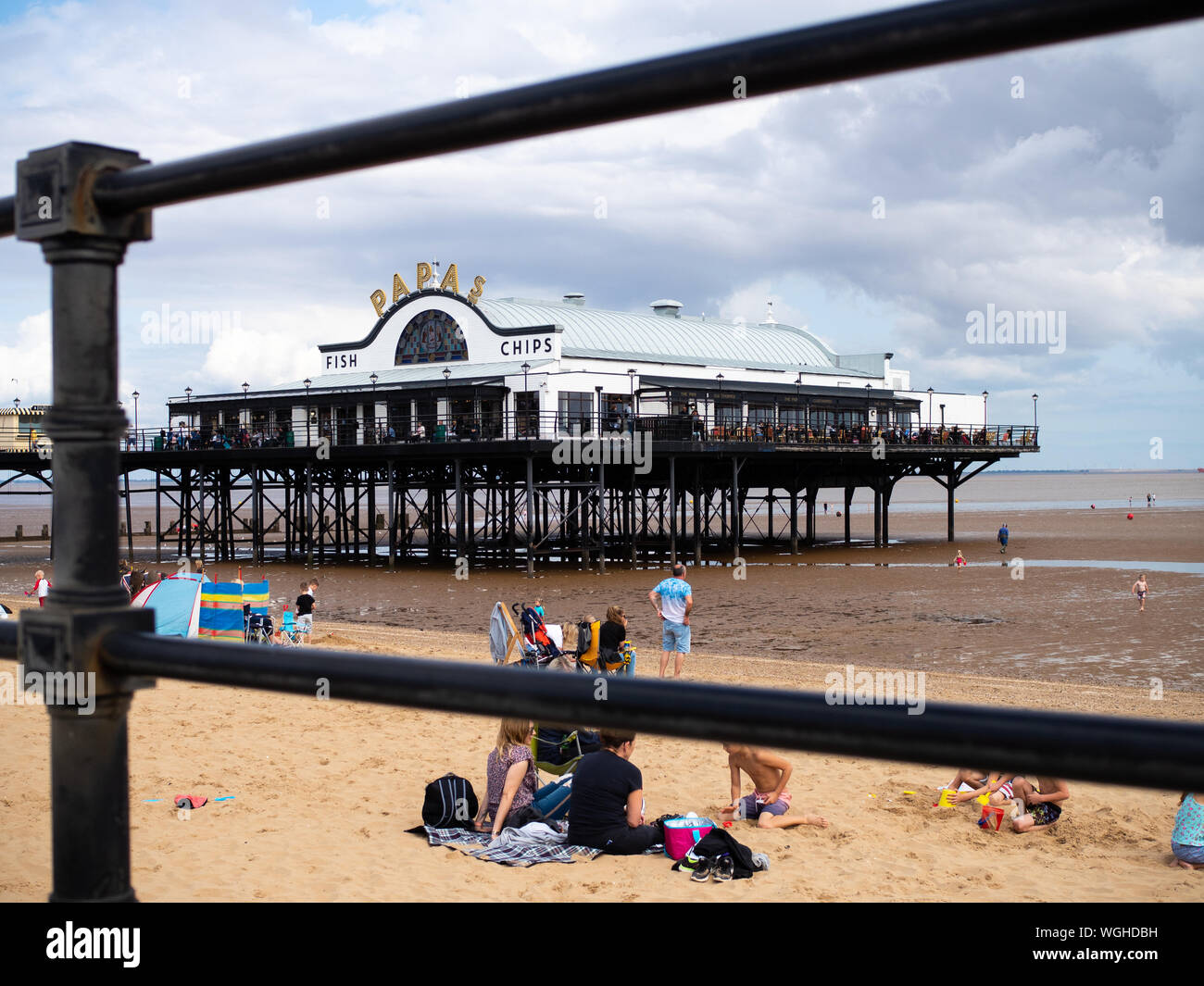 Cleethorpe Pier and beach entertain British seaside tourists, incidental people in frame. Stock Photo