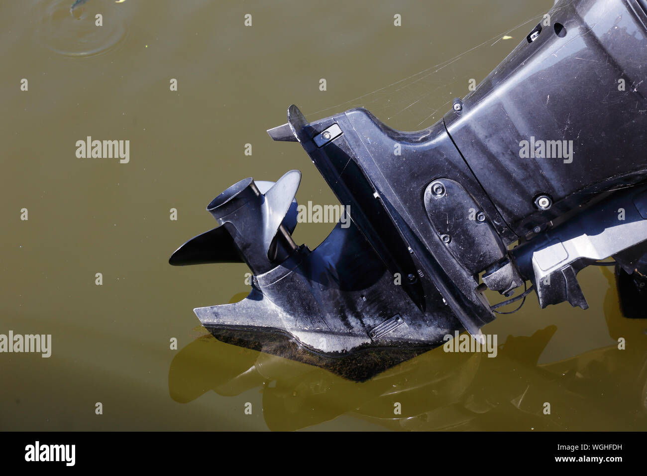 Close up of an outboard motor partial raised from the water. Stock Photo