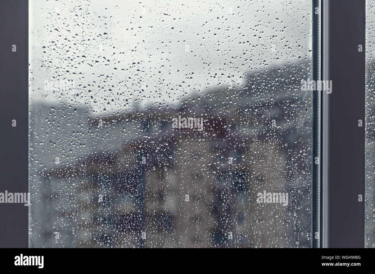 Rain drops on window glass is viewing city buildings on a bad weather