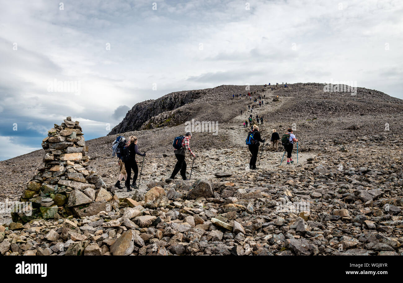 People hiking on the Ben Nevis summit, in the Scottish Highlands. Ben Navis is the highest mountain in the British Isles. Stock Photo