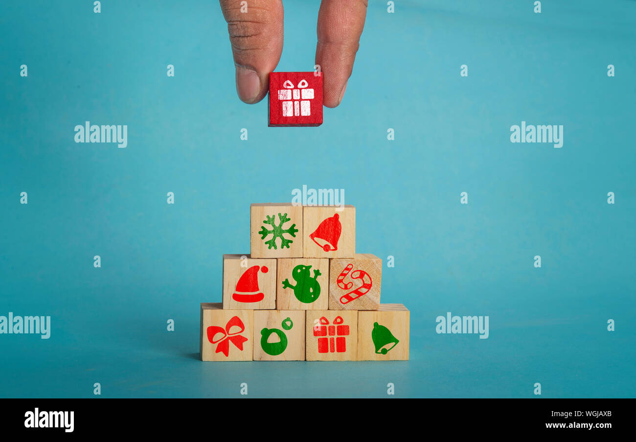 Christmas icons on wooden blocks with man hand, copy space for your text Stock Photo