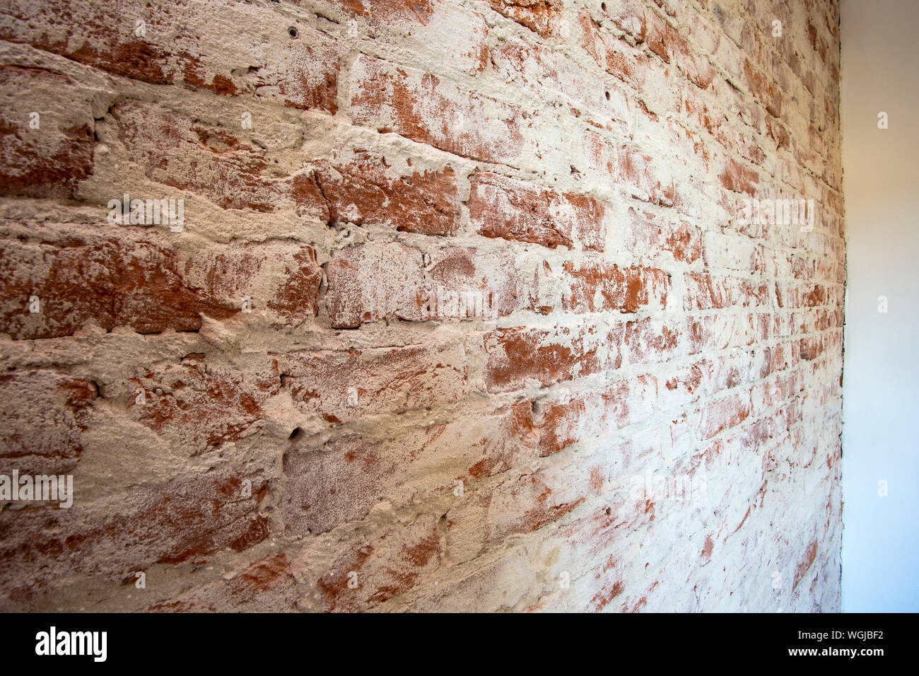 Weathered stained red brick wall background texture peeling plaster Stock Photo