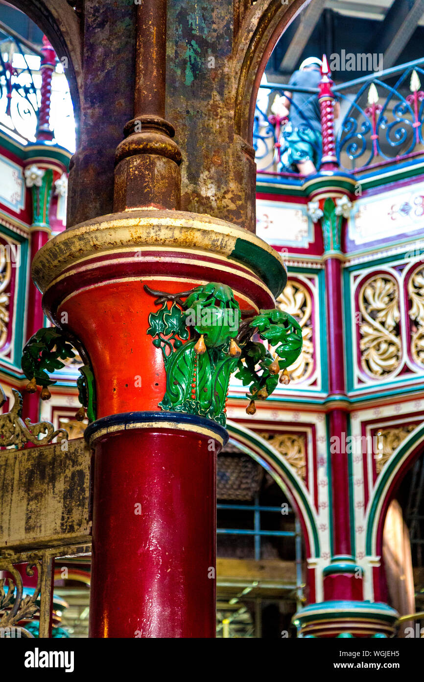Partially restored intricate ironwork featuring fig leaves around a column at the Victorian Crossness Pumping Station, UK Stock Photo