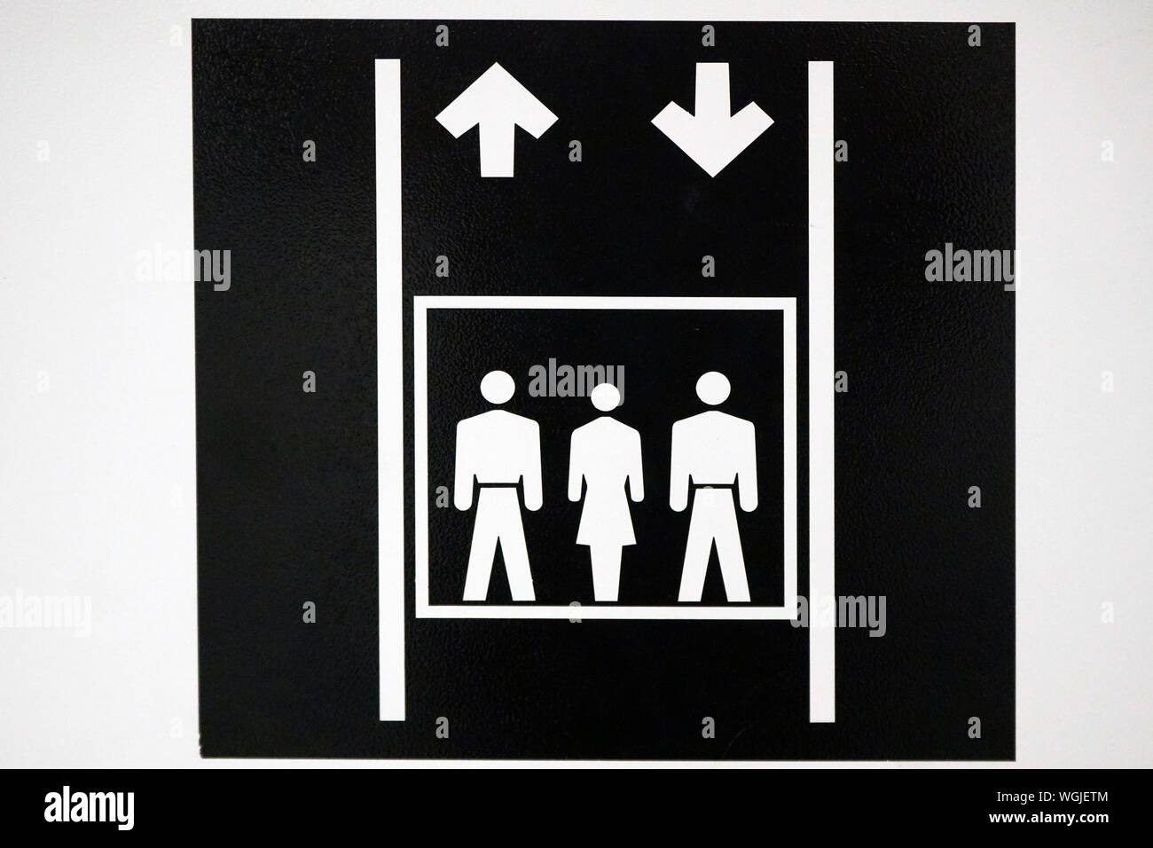 Elevator - lift sign with two men and one woman graphics and two arrows and lines Stock Photo
