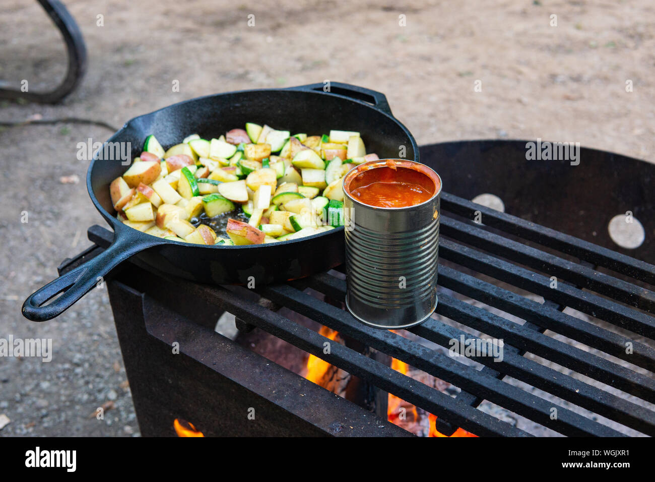 Cooking veggies and beans over campfire rustic camping Stock Photo Alamy