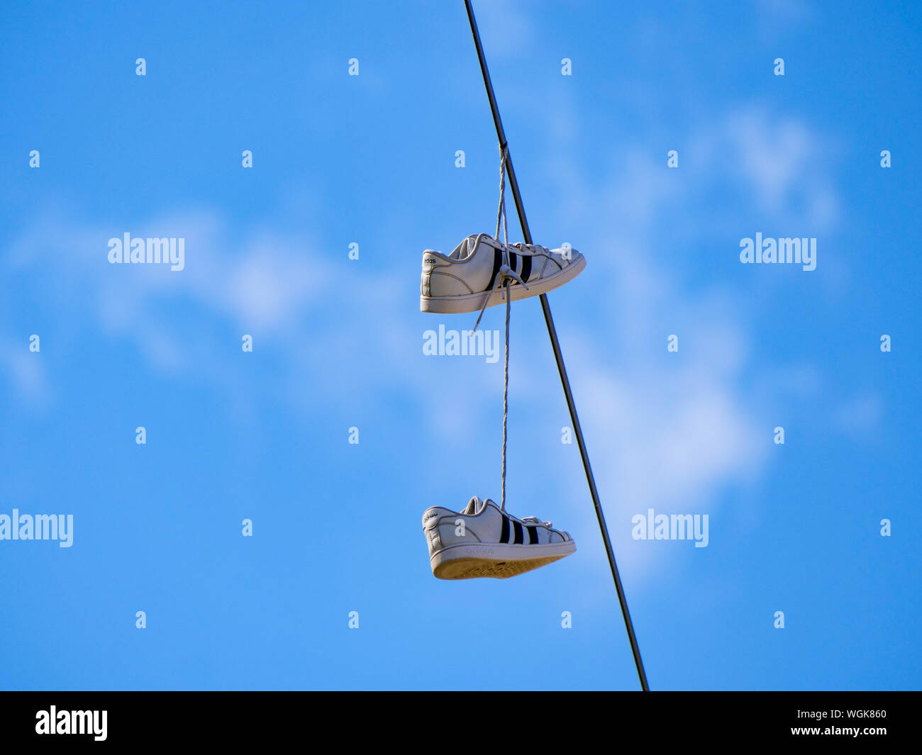 Sneakers hanging from utility wire Stock Photo Alamy