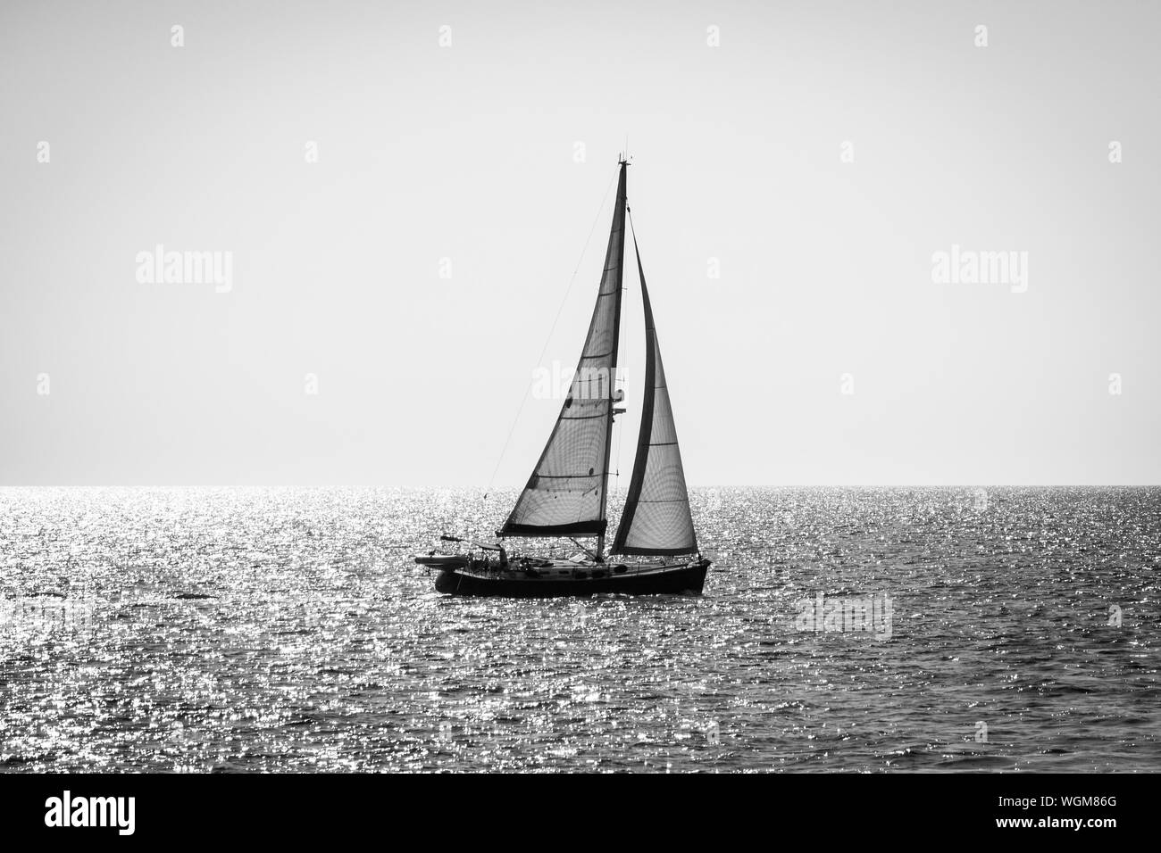 Alone yacht sailing in sea water, black and white image, backlight  silhouette Stock Photo - Alamy