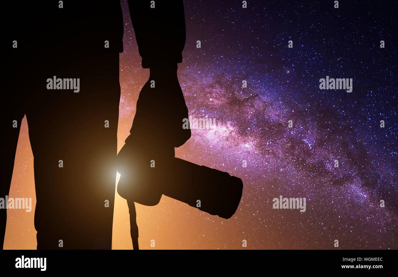 Midsection Of Silhouette Man Holding Camera Against Star Field Stock Photo