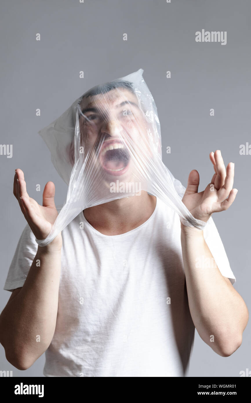 Shouting and captivated man fighting against a plastic bag. Pollution concept Stock Photo