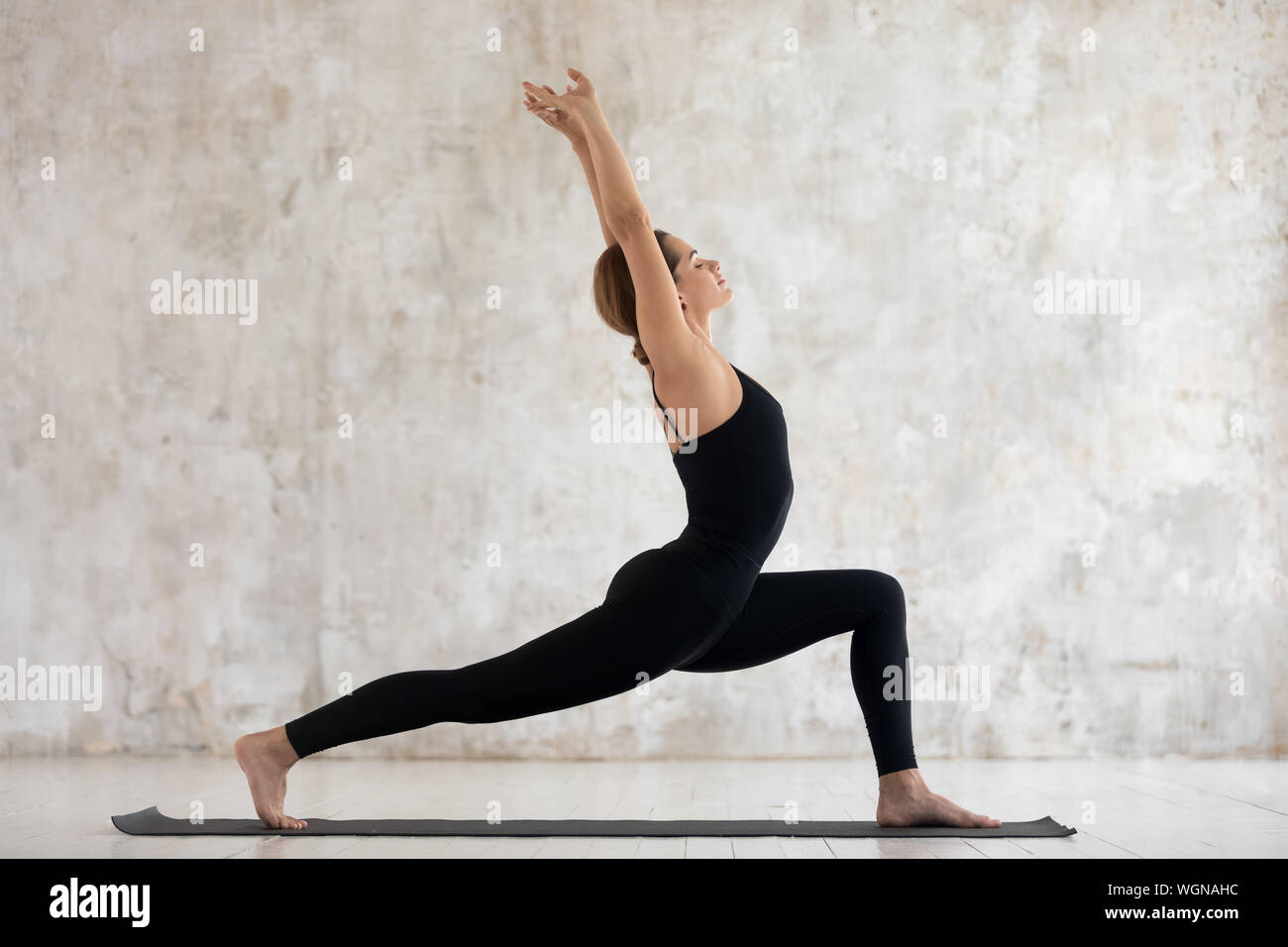 Young Woman Practicing Yoga Standing In Warrior One Pose Virabhadrasana Stock Photo Alamy