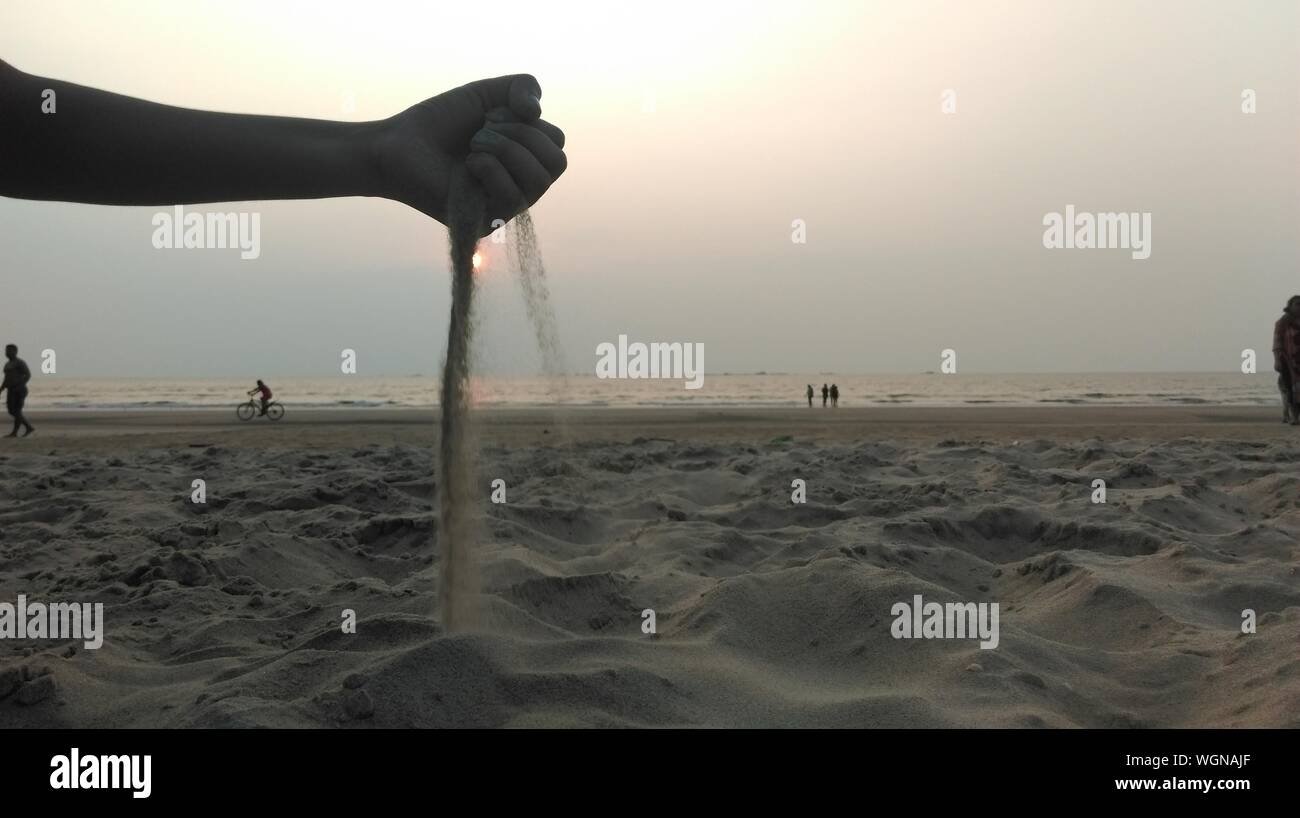 Man's Hand Releasing Sand Stock Photo