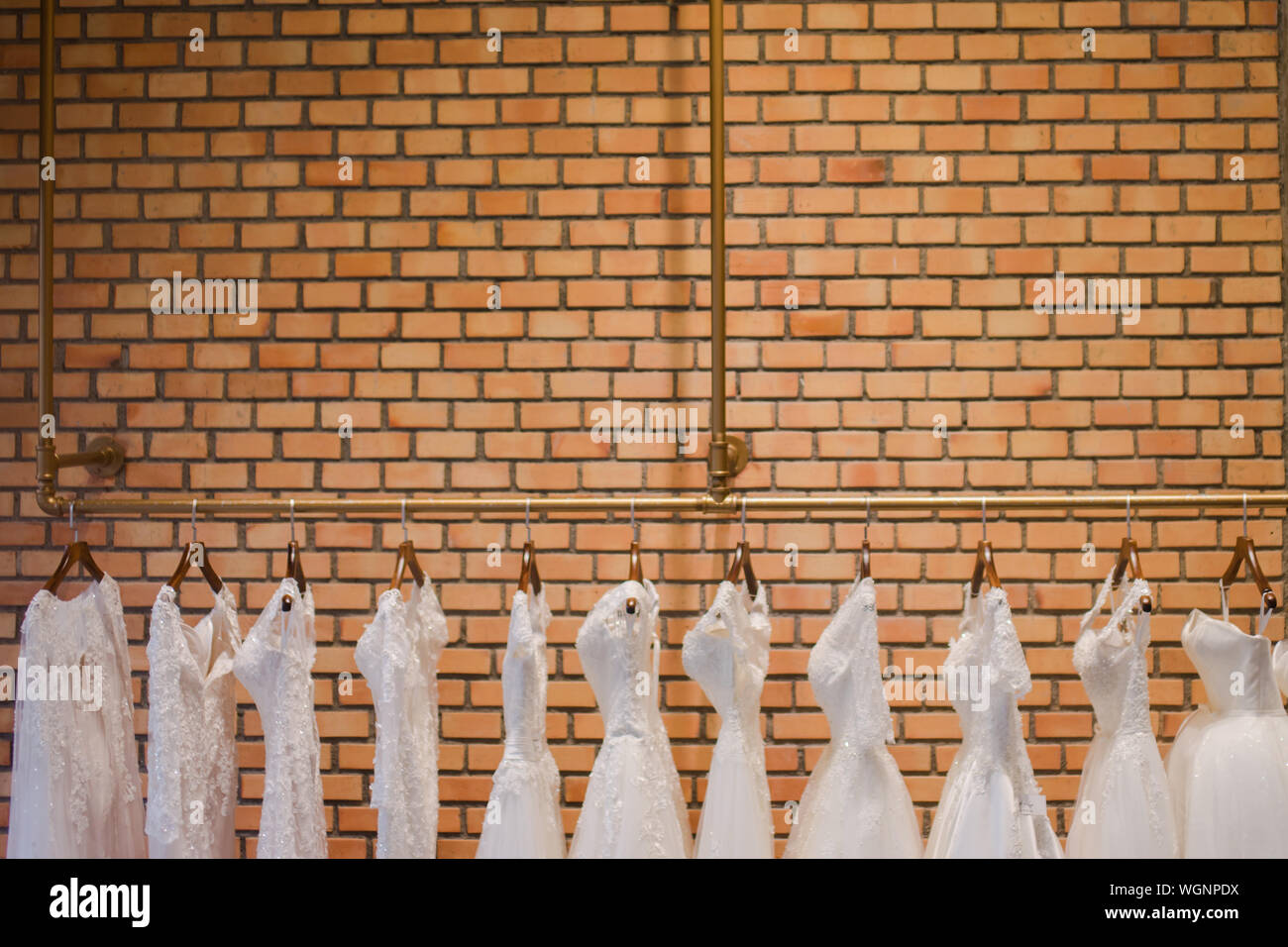 Dresses Hanging Against Brick Wall Stock Photo
