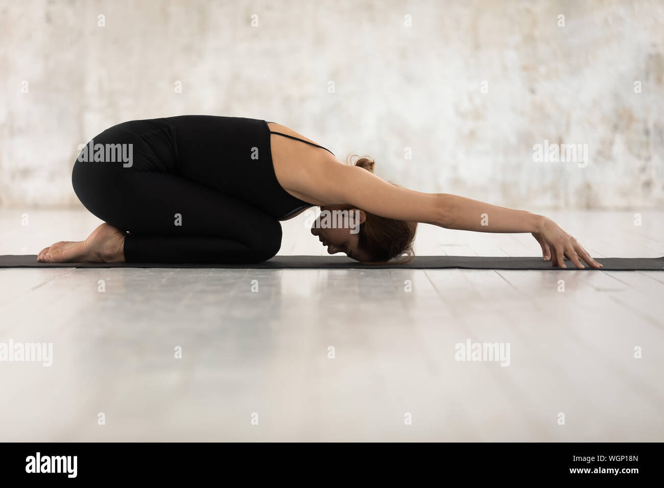 Beautiful woman practicing yoga, relaxing in Child pose, Balasana exercise Stock Photo