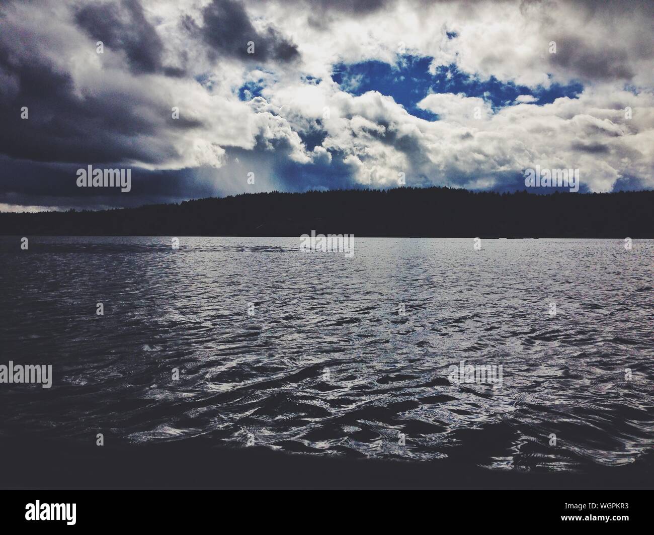 Choppy Waters On A Forest Lake With Menacing Clouds Stock Photo