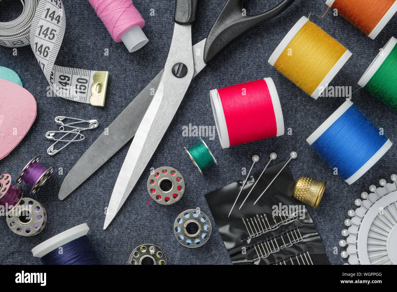 Sewing items: tailoring scissors, measuring tape, thimble, spools