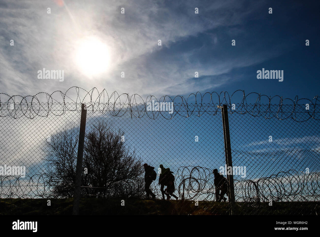 Refugees Running On Border Against Sky Stock Photo