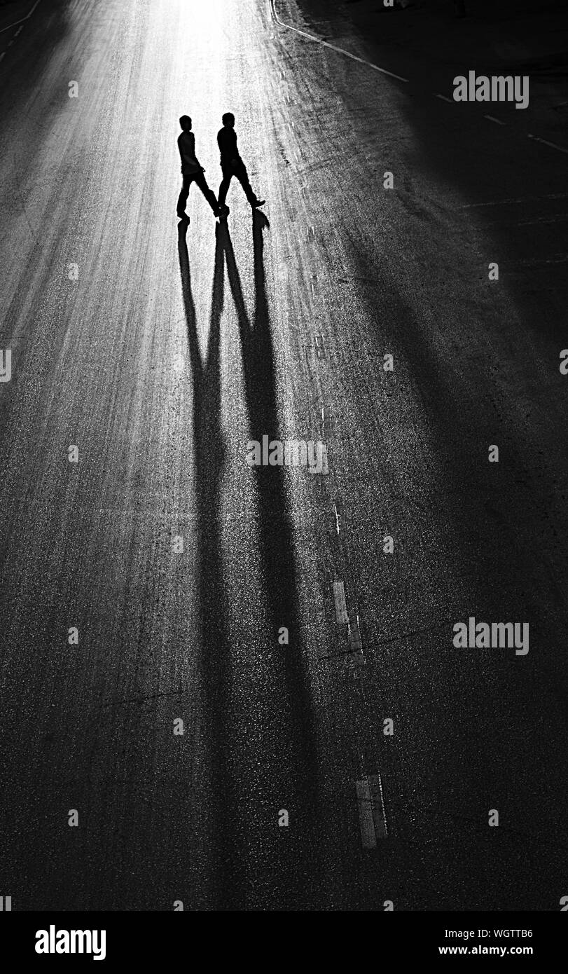 Two people crossing road silhouette Black and White Stock Photos