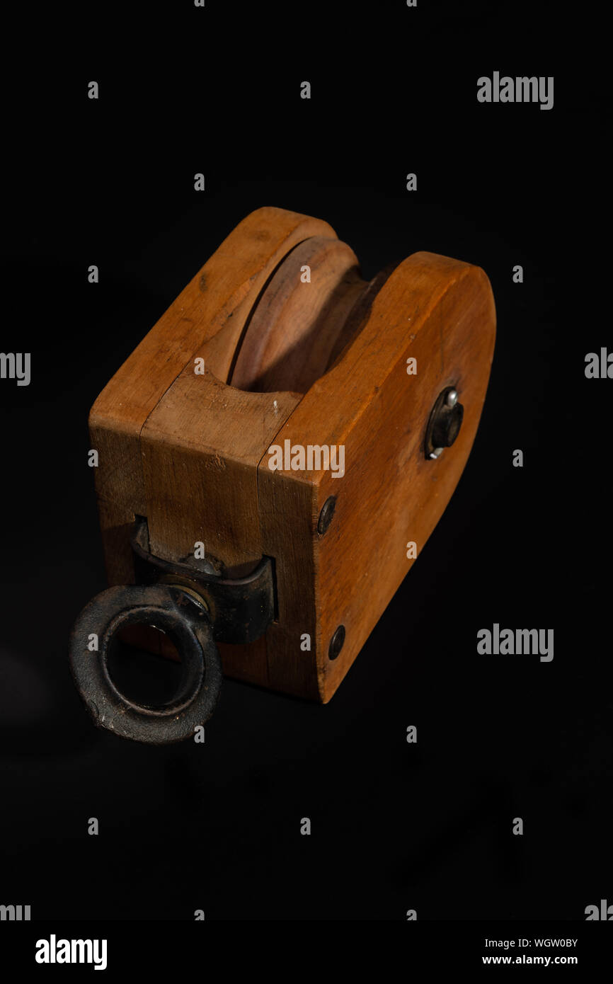 Vintage wooden pulley block isolated on a black background Stock Photo