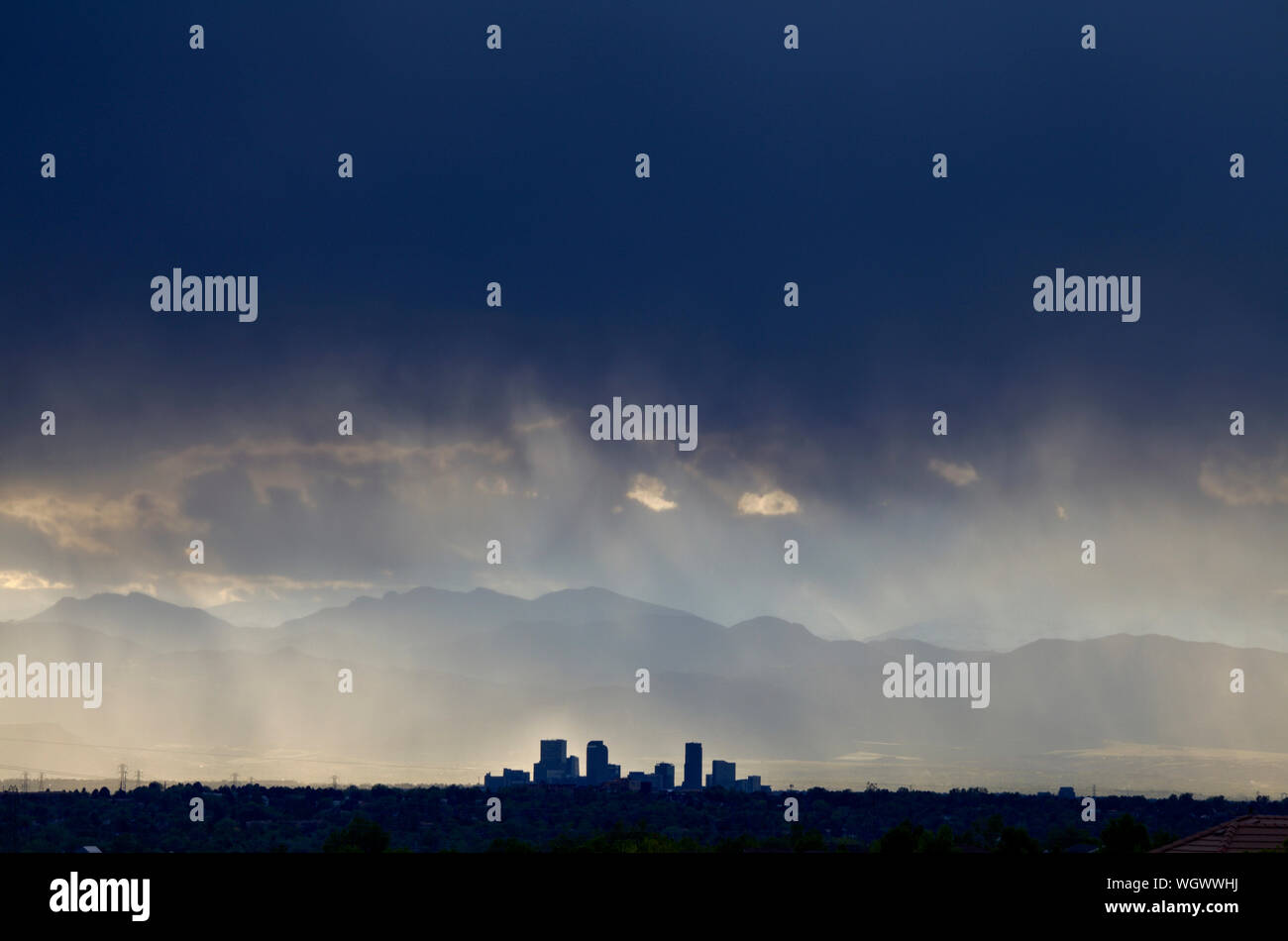 Denver Colorado's skyline facing west with the front range mountains in the background during a rain shower. Stock Photo